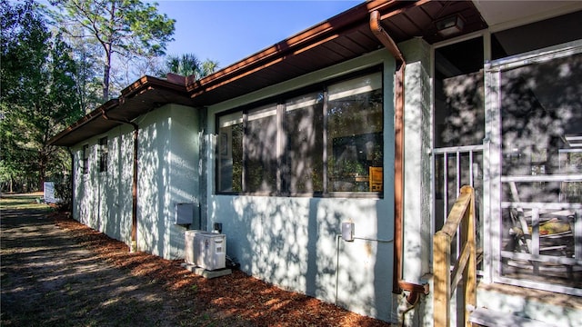 view of side of property featuring central AC and stucco siding