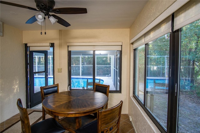 dining area featuring a ceiling fan and a textured wall