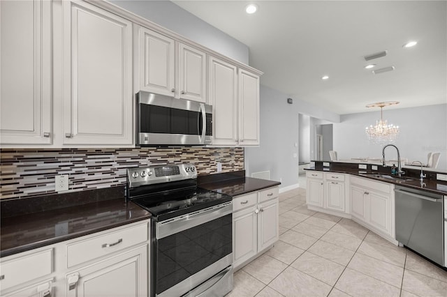 kitchen featuring sink, appliances with stainless steel finishes, tasteful backsplash, white cabinets, and light tile patterned flooring