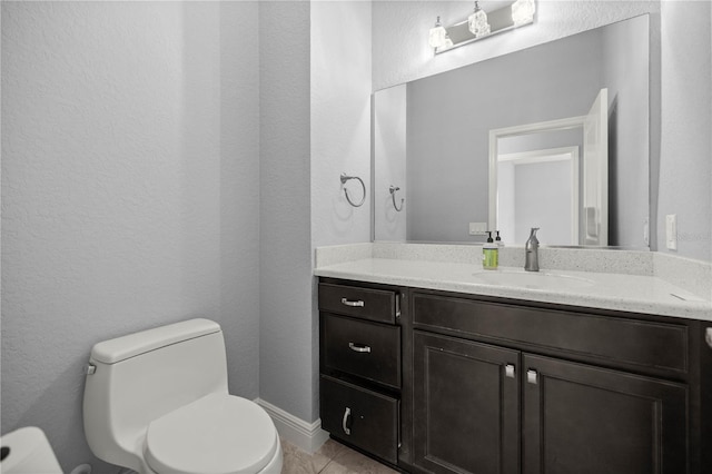 bathroom featuring vanity, toilet, and tile patterned flooring