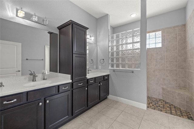 bathroom with vanity, tile patterned flooring, and a tile shower