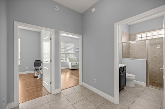 bathroom with vanity, toilet, tile patterned floors, and a shower with shower door