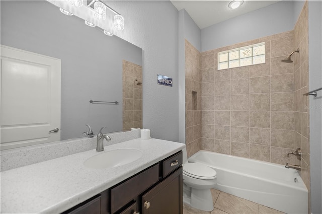 full bathroom featuring tiled shower / bath combo, vanity, tile patterned floors, and toilet