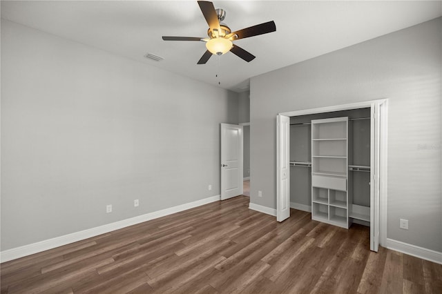 unfurnished bedroom with dark wood-type flooring, a closet, and ceiling fan