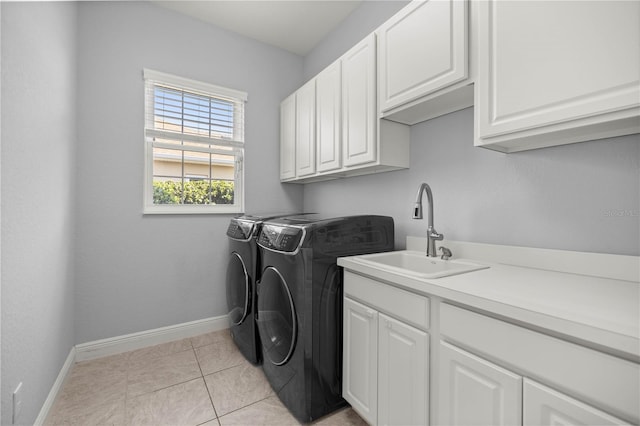 washroom featuring cabinets, sink, washing machine and dryer, and light tile patterned floors