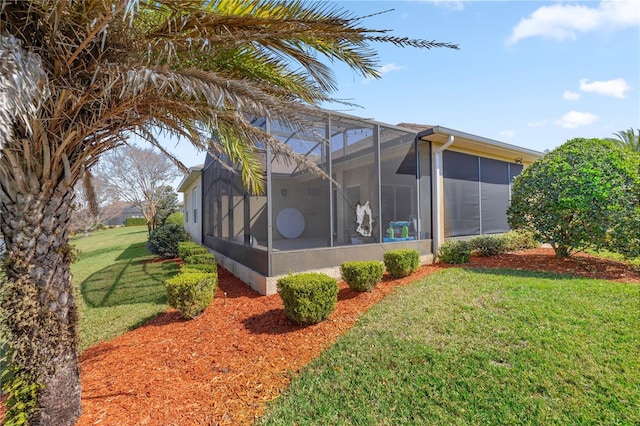 view of home's exterior with a lawn and glass enclosure