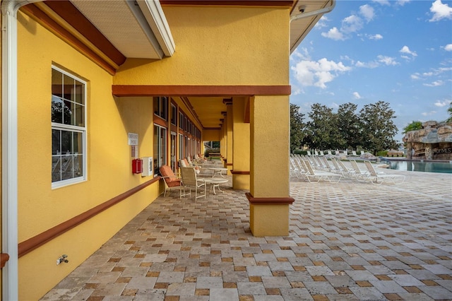 view of patio / terrace featuring a community pool and a water view