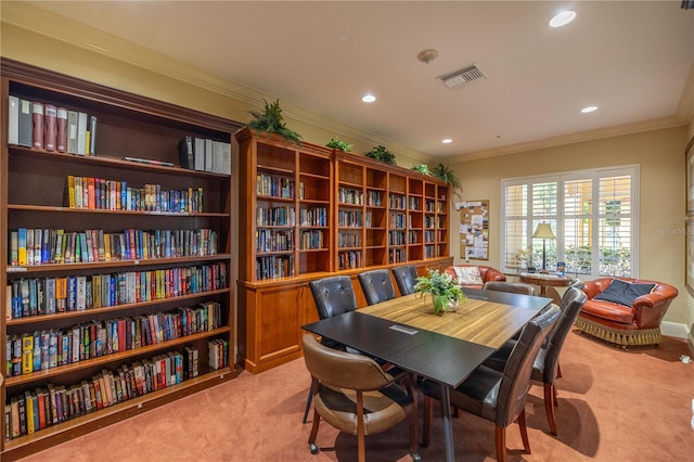 carpeted dining space featuring crown molding