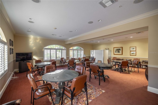 carpeted dining space with crown molding