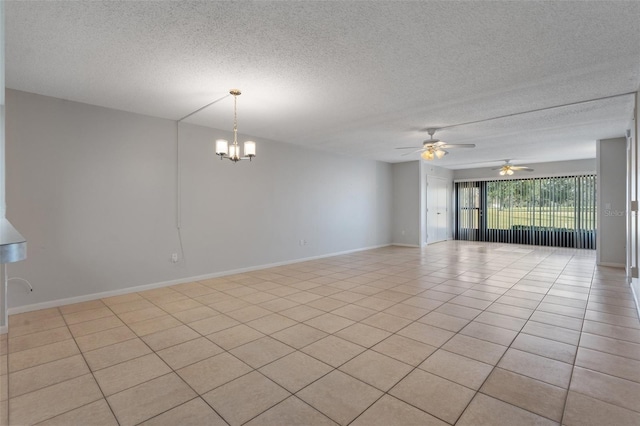 tiled spare room with ceiling fan with notable chandelier and a textured ceiling