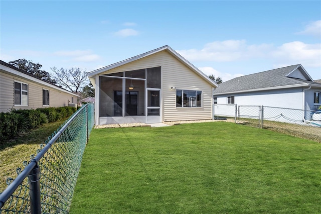 rear view of property with a sunroom and a lawn