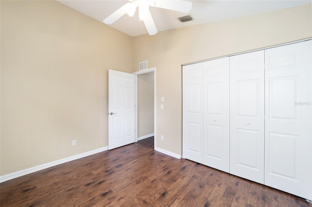 unfurnished bedroom with dark hardwood / wood-style flooring, vaulted ceiling, a closet, and ceiling fan