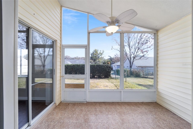 unfurnished sunroom with ceiling fan