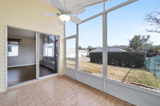 unfurnished sunroom with a wealth of natural light and ceiling fan