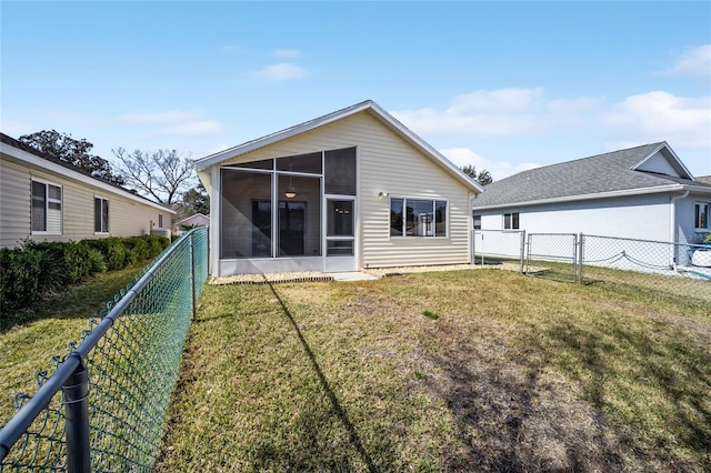 back of property with a sunroom and a lawn