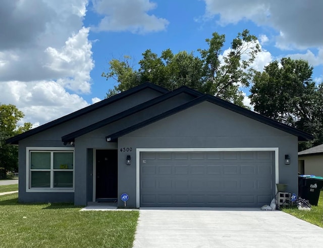 ranch-style house featuring a garage, stucco siding, driveway, and a front lawn