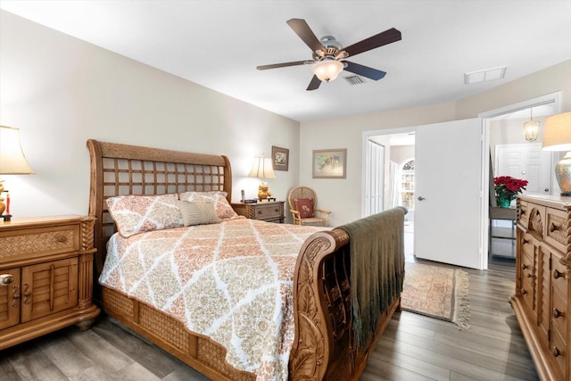 bedroom with dark hardwood / wood-style flooring and ceiling fan