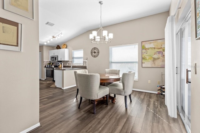 dining area featuring vaulted ceiling, dark hardwood / wood-style floors, sink, and a notable chandelier