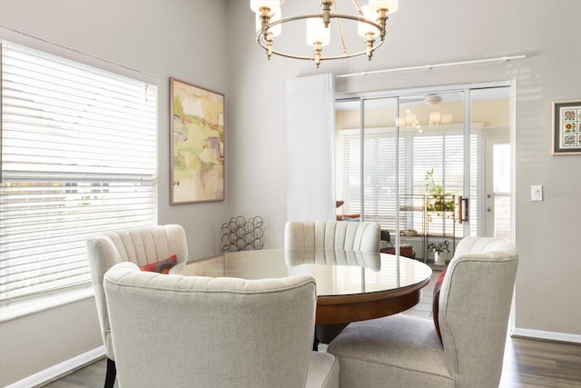 dining area with dark hardwood / wood-style flooring and a notable chandelier