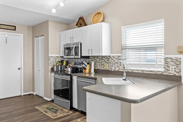 kitchen with sink, backsplash, stainless steel appliances, and white cabinets