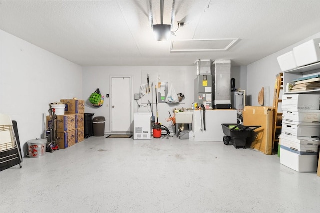 garage featuring heating unit, sink, and a garage door opener