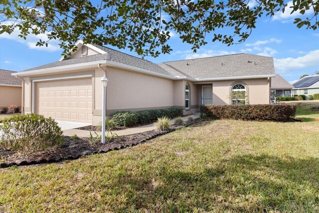 single story home featuring a garage and a front lawn