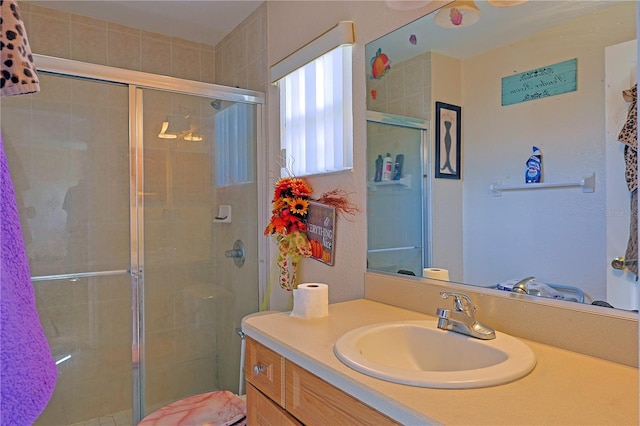 bathroom featuring vanity and a shower with door