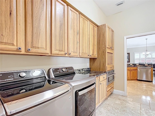 7688 SE 135th St, Summerfield, FL 34491 - washroom featuring ornamental molding, washing machine and dryer, cabinets, and a chandelier