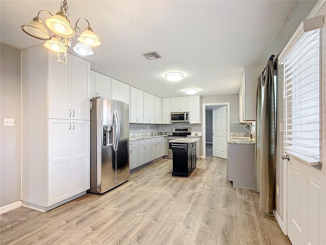 kitchen featuring tasteful backsplash, appliances with stainless steel finishes, a center island, and hanging light fixtures