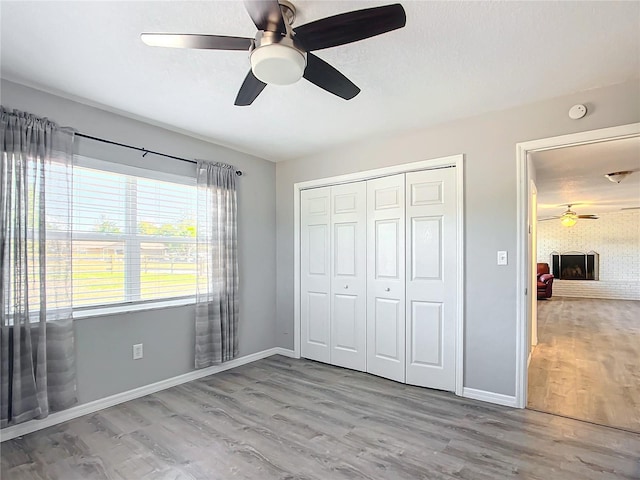 unfurnished bedroom featuring ceiling fan, light hardwood / wood-style floors, and a closet