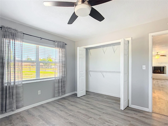 unfurnished bedroom with wood-type flooring, ceiling fan, and a closet