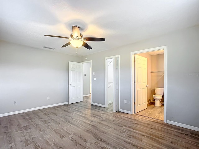 unfurnished bedroom featuring ceiling fan, connected bathroom, and light wood-type flooring