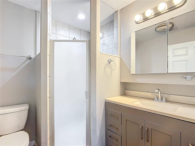 bathroom with vanity, toilet, and a shower with shower door