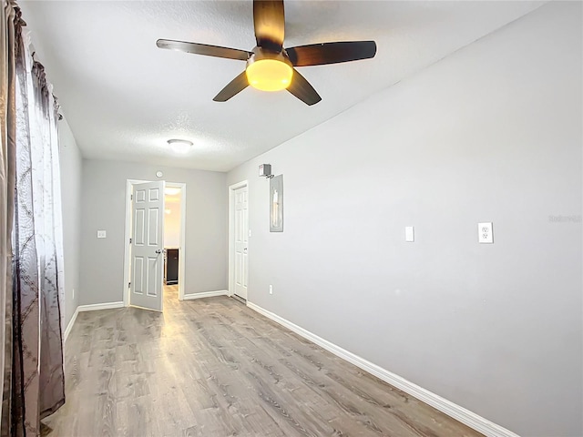 empty room featuring ceiling fan, light hardwood / wood-style floors, and a textured ceiling