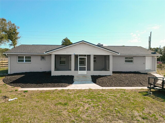 single story home with a sunroom and a front yard