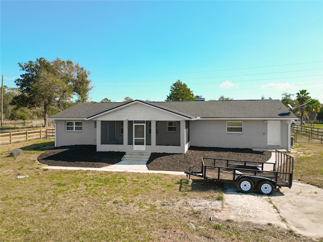 view of front of home featuring a sunroom and a front yard