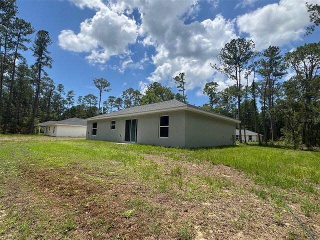 9971 N Bamboo Way, Citrus Springs, FL 34434 - rear view of house featuring stucco siding and a yard