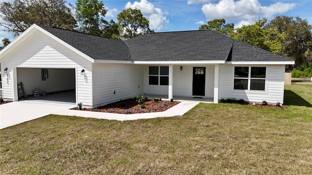 view of front of house featuring an attached garage, a front yard, roof with shingles, and concrete driveway