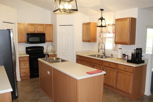 kitchen featuring decorative light fixtures, an island with sink, sink, and black appliances