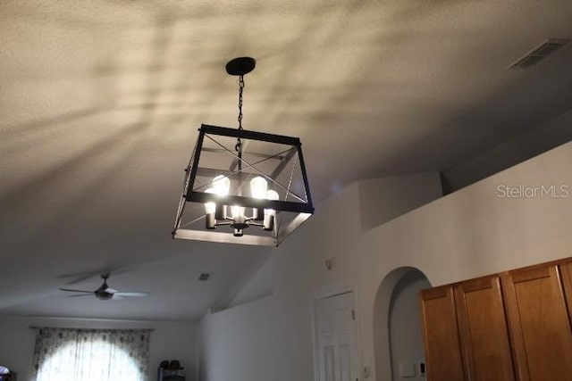 interior details with ceiling fan with notable chandelier