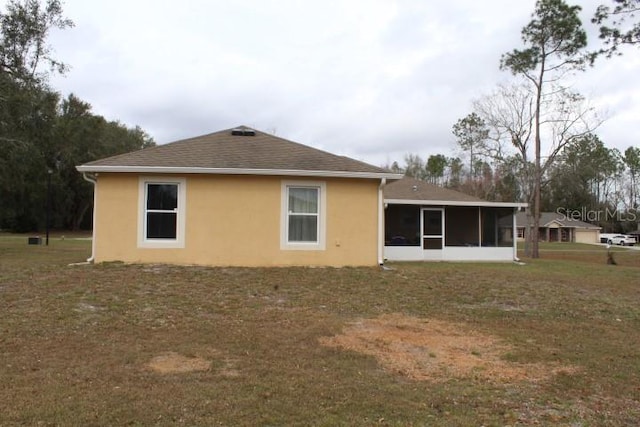 rear view of property featuring a sunroom and a yard