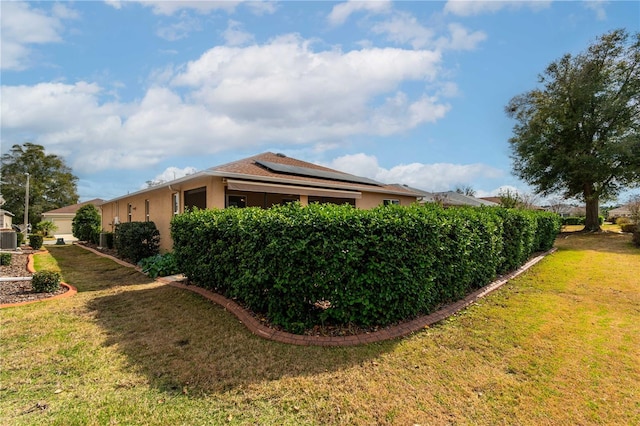 view of home's exterior featuring a lawn and solar panels