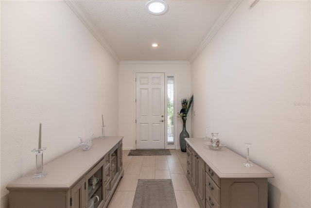 tiled foyer entrance with crown molding and a textured ceiling