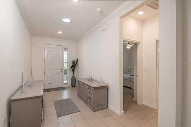 entryway with ceiling fan, ornamental molding, and a textured ceiling