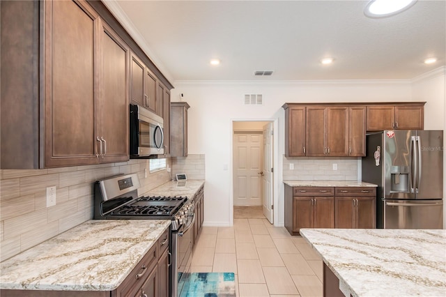 kitchen with light stone countertops, appliances with stainless steel finishes, ornamental molding, and backsplash