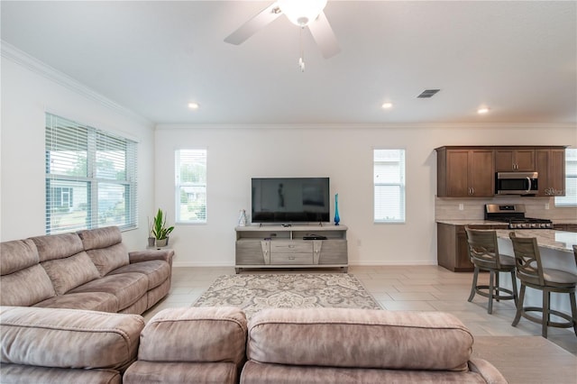 living room featuring ornamental molding and ceiling fan