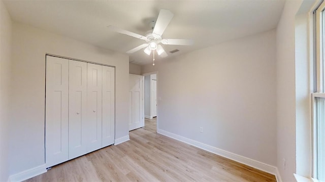 unfurnished bedroom with light hardwood / wood-style floors, a closet, and ceiling fan