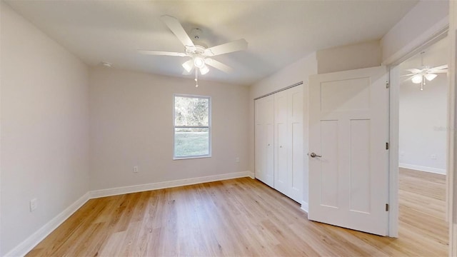 unfurnished bedroom with ceiling fan, light wood-type flooring, and a closet