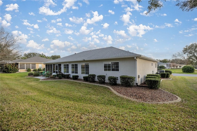 rear view of property featuring a lawn