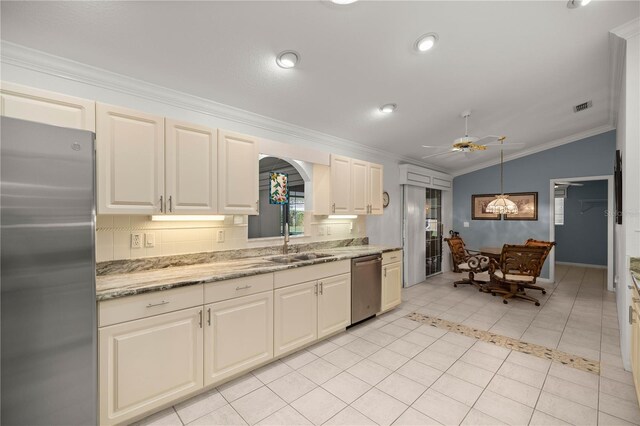 kitchen featuring sink, light tile patterned floors, stainless steel appliances, decorative light fixtures, and vaulted ceiling